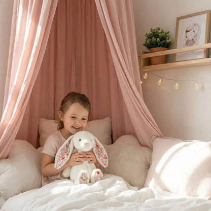 petite fille avec son doudou lapin blanc au lit