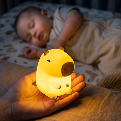 Veilleuse bébé capybara sur mains maman éclairé son bébé
