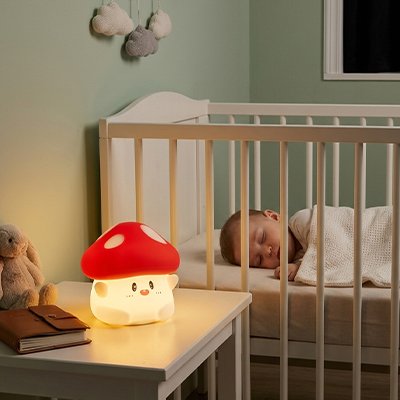 Veilleuse bébé champignon allumé sur table bébé dort dans berceau