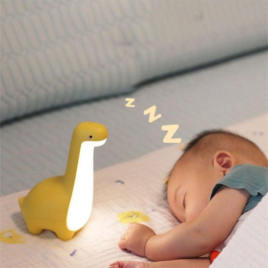 Veilleuse bébé dinosaure jaune bébé dort paisiblement