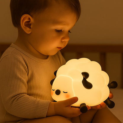 Veilleuse bébé mouton allumée dans bras bébé